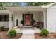 Inviting front porch with decorative columns, a brick facade, and a vibrant red door at 1109 S Highland Ave, Landis, NC 28088