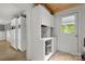 Bright laundry room with ample white cabinets and wood-look flooring, next to an exterior door at 1109 S Highland Ave, Landis, NC 28088