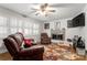 Inviting living room with a brick fireplace, fan, and shuttered windows at 1109 S Highland Ave, Landis, NC 28088