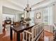 Dining room features chandelier, dark wood table, bench seating and view into the living room at 1109 Woodwinds Dr, Waxhaw, NC 28173