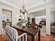 Dining room features chandelier, dark wood table, bench seating and view into the living room and kitchen at 1109 Woodwinds Dr, Waxhaw, NC 28173