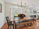 Bright dining room with hardwood floors, large windows, and an elegant chandelier above the table at 1109 Woodwinds Dr, Waxhaw, NC 28173