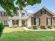 Charming two-story home with a well-manicured lawn and a welcoming front porch with black shutters at 1109 Woodwinds Dr, Waxhaw, NC 28173