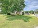 Well-manicured front yard with mature trees and lush lawn enhances the curb appeal of this charming home at 1109 Woodwinds Dr, Waxhaw, NC 28173