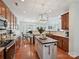 Open-concept kitchen features wood cabinets, stainless steel appliances, hardwood floors and large center island at 1109 Woodwinds Dr, Waxhaw, NC 28173