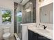 Modern bathroom features a tiled shower with glass door, white vanity, and natural light from a window at 112 Manning Dr, Charlotte, NC 28209