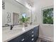 Bathroom with double vanity, quartz countertops, and a large window with a view of the trees at 112 Manning Dr, Charlotte, NC 28209