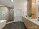 Modern bathroom featuring dual vanities, a glass shower, and a soaking tub at 112 Manning Dr, Charlotte, NC 28209