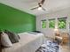 Bright bedroom with green accent wall, ceiling fan, and three windows with a view of the trees at 112 Manning Dr, Charlotte, NC 28209