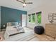 Bedroom with blue accent wall, three windows, ceiling fan, and hardwood flooring at 112 Manning Dr, Charlotte, NC 28209