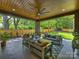 Covered patio with seating, ceiling fan and wood ceiling overlooking the lush backyard at 112 Manning Dr, Charlotte, NC 28209