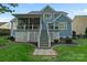 A backyard featuring a two-story home with a back porch and patio, set against a well-manicured lawn at 118 Tuscany Trl, Mooresville, NC 28117