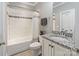 A bathroom featuring a tub with tiled walls, a granite vanity top, and neutral color scheme at 118 Tuscany Trl, Mooresville, NC 28117