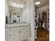 Bathroom featuring a dual sink vanity with granite countertop and a large walk-in closet with custom shelving at 118 Tuscany Trl, Mooresville, NC 28117