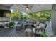 An open-air screened porch featuring a ceiling fan, seating area with a firepit, and a view of the backyard at 118 Tuscany Trl, Mooresville, NC 28117