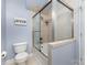 Cozy bathroom highlighting a bathtub with glass doors, tiled walls, and a standard toilet at 121 Quality Dr, Mount Holly, NC 28120