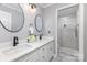 Elegant bathroom features double sink vanity, black fixtures, decorative mirrors and tiled walk-in shower at 121 Quality Dr, Mount Holly, NC 28120