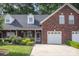 Inviting brick home with dormer windows, a well-kept lawn, and an attached garage at 121 Quality Dr, Mount Holly, NC 28120