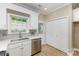 Well-lit kitchen area with stainless steel appliances, a window with a view, and direct access to the back door at 121 Quality Dr, Mount Holly, NC 28120