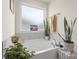 Bright bathroom with a soaking tub, plants, and tile backsplash at 13327 Savaine St, Charlotte, NC 28278