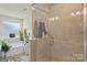 Modern bathroom with a soaking tub, glass shower, and neutral tile at 13327 Savaine St, Charlotte, NC 28278