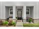 Inviting front porch featuring stone accents, a cozy bench, and decorative potted plants at 13327 Savaine St, Charlotte, NC 28278