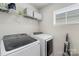 Well-equipped laundry room featuring modern washer and dryer, storage shelves, and ample space at 13327 Savaine St, Charlotte, NC 28278