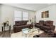 Inviting living room with plush leather seating, a glass coffee table, and bright natural light from the windows at 13327 Savaine St, Charlotte, NC 28278
