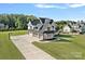 Aerial view of a stunning two-story home showcasing its well-manicured lawn, basketball court, and multi-car garage at 1405 Waxhaw Marvin Rd, Waxhaw, NC 28173