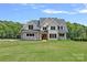 Beautiful two-story home with brick accents, complemented by a lush green lawn and mature trees at 1405 Waxhaw Marvin Rd, Waxhaw, NC 28173