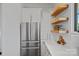 This is a close up of a contemporary kitchen design, featuring stainless steel appliances, floating wooden shelves, and modern cabinetry at 1405 Waxhaw Marvin Rd, Waxhaw, NC 28173