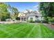 Expansive backyard with well-manicured lawn, a patio area, and mature trees providing shade at 167 Quaker Rd, Mooresville, NC 28117