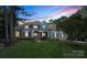 Elegant home with manicured lawn, stone accents, covered porch and stunning evening sky backdrop at 167 Quaker Rd, Mooresville, NC 28117