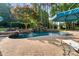 Stunning pool area with waterfall features, brick patio, and lounge seating for relaxing outdoors at 167 Quaker Rd, Mooresville, NC 28117