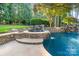 Beautiful pool featuring a stone waterfall and a tranquil hot tub, ideal for outdoor relaxation at 167 Quaker Rd, Mooresville, NC 28117