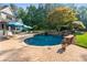 Inviting pool and patio area with waterfall feature, complete with lounge chairs and shaded seating at 167 Quaker Rd, Mooresville, NC 28117