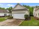A view of a well maintained garage with a white door and surrounding landscaping at 19157 Mallard Dr, Fort Mill, SC 29707