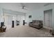Open living room with large windows, neutral carpet, a ceiling fan, and modern electronics at 19157 Mallard Dr, Fort Mill, SC 29707