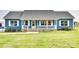 Charming single-story home featuring blue siding, a welcoming front porch, and a well-manicured lawn at 2268 Westbrook Rd, Edgemoor, SC 29712