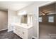 Bright bathroom featuring a double vanity, a mirror, tile flooring, and a doorway to the main bedroom at 2728 Touchstone Cir, Newton, NC 28658