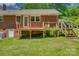 Back of a brick home with a wooden deck and stairs leading to the yard at 286 Southside Rd, Rock Hill, SC 29730