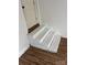 A newly painted white stairway with wood floors leads up to a door in this house at 286 Southside Rd, Rock Hill, SC 29730
