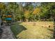 Beautifully landscaped backyard with mature trees, a patio, a playground, and a well-manicured lawn at 35 Dorie Dr, Belmont, NC 28012