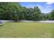 Lush backyard with a large green lawn and a white fence, surrounded by mature trees for added privacy at 3807 Sweetgrass Ln, Charlotte, NC 28226