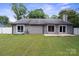 Spacious backyard featuring a gray-sided house with multiple sliding glass doors and a pristine lawn at 3807 Sweetgrass Ln, Charlotte, NC 28226