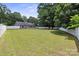 Lush backyard with a large lawn and a white fence, surrounded by trees and featuring the rear of the house at 3807 Sweetgrass Ln, Charlotte, NC 28226