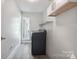 Clean laundry room featuring modern appliances, overhead shelving, and plenty of natural light at 3807 Sweetgrass Ln, Charlotte, NC 28226