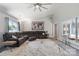Spacious living room featuring a sectional sofa, large windows, and a modern ceiling fan at 3807 Sweetgrass Ln, Charlotte, NC 28226