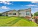 Well-maintained backyard features a green lawn, pergola, and a stone retaining wall with flowering plants at 417 Brier Knob Dr, Fort Mill, SC 29715