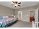A cozy bedroom features a ceiling fan, colorful quilt, and nearby access to the bathroom and bonus room at 417 Brier Knob Dr, Fort Mill, SC 29715